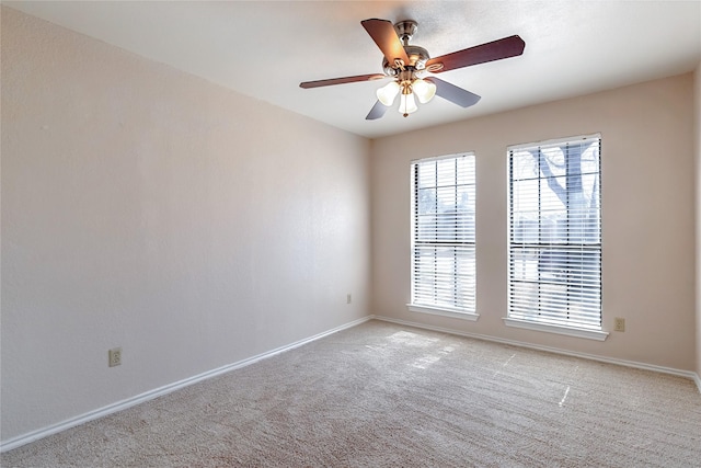 unfurnished room with baseboards, a ceiling fan, and light colored carpet