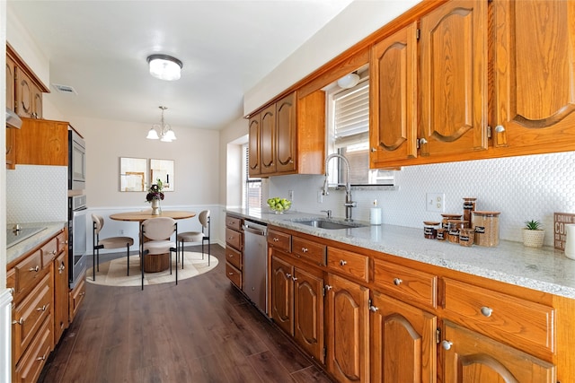 kitchen with visible vents, dark wood finished floors, brown cabinets, stainless steel appliances, and a sink