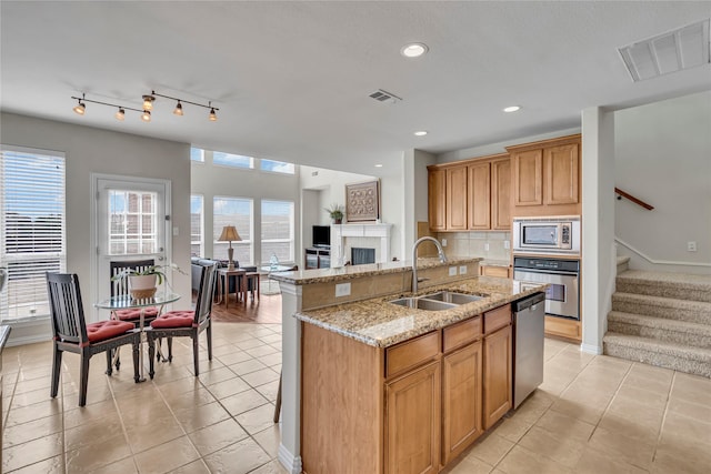 kitchen featuring stainless steel appliances, open floor plan, visible vents, and a sink