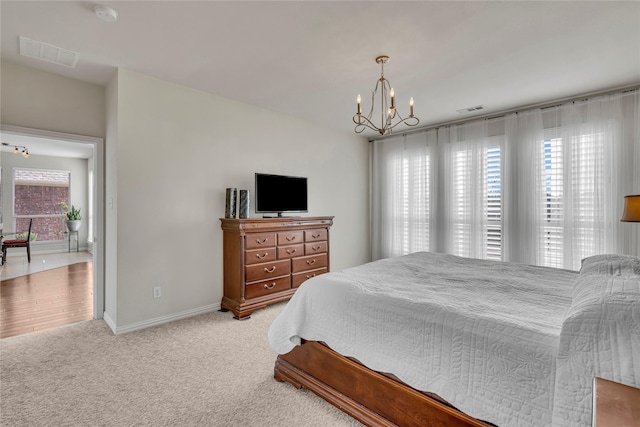 carpeted bedroom featuring visible vents, a notable chandelier, and baseboards