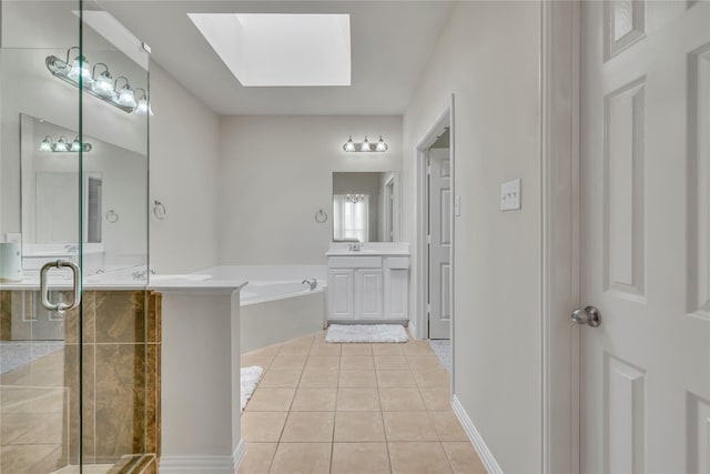 bathroom featuring a skylight, a garden tub, a stall shower, vanity, and tile patterned flooring