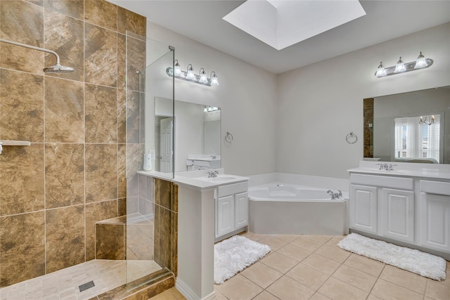 bathroom with a skylight, a garden tub, a sink, a walk in shower, and tile patterned flooring