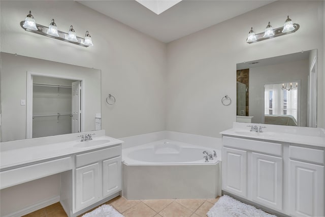 full bath featuring a garden tub, two vanities, a sink, and tile patterned floors