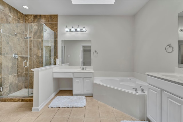 full bath with a skylight, tile patterned flooring, a sink, and a shower stall