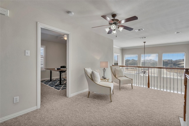 sitting room featuring carpet floors, crown molding, visible vents, ceiling fan, and baseboards