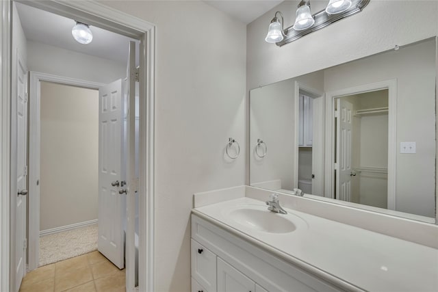 bathroom with toilet, tile patterned flooring, and vanity