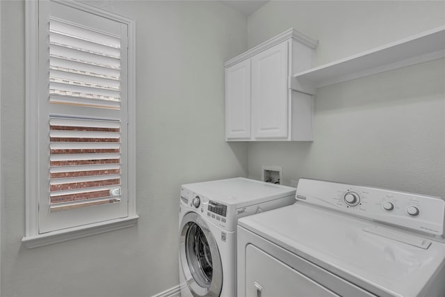 clothes washing area with plenty of natural light, cabinet space, and washer and dryer