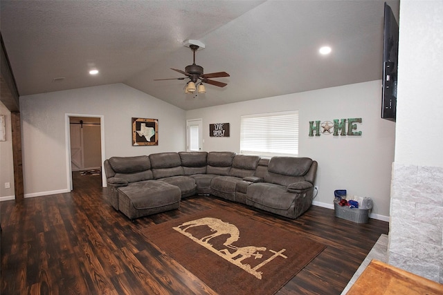 living area featuring a barn door, baseboards, a ceiling fan, wood finished floors, and vaulted ceiling