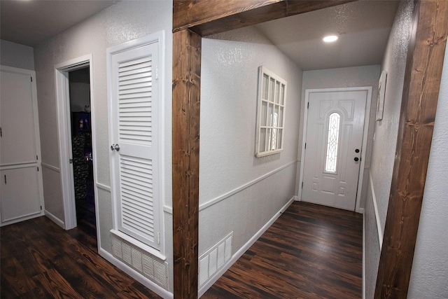 interior space featuring dark wood-style flooring, visible vents, and baseboards