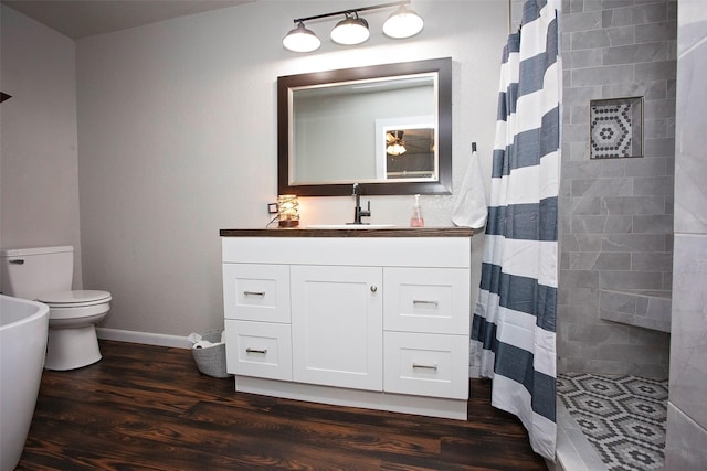 full bath with baseboards, toilet, wood finished floors, curtained shower, and vanity