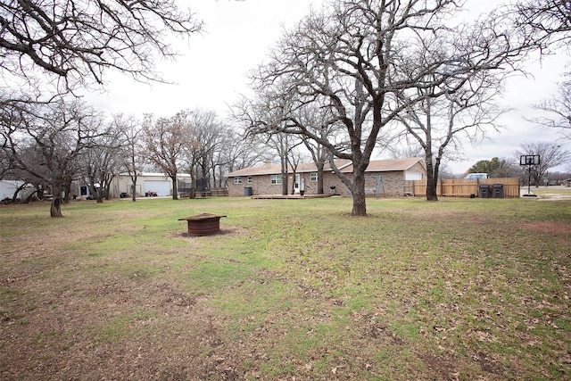 view of yard with a fire pit and fence