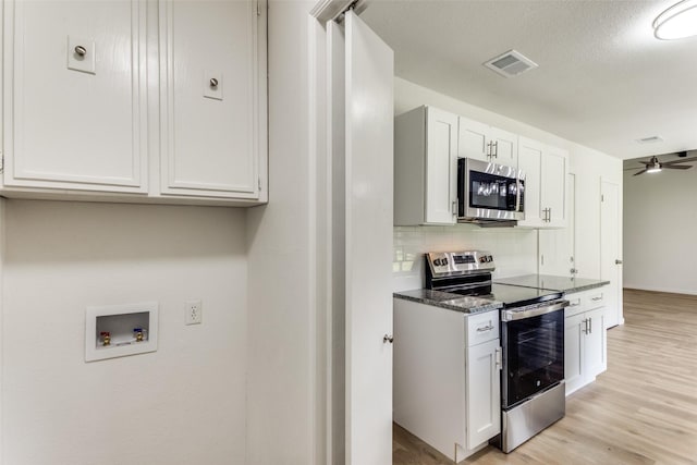 kitchen featuring stainless steel appliances, visible vents, light wood-style flooring, backsplash, and a ceiling fan