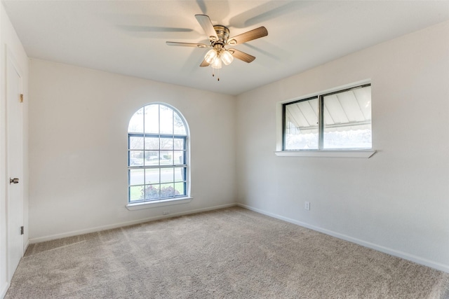 spare room with carpet floors, a ceiling fan, and baseboards