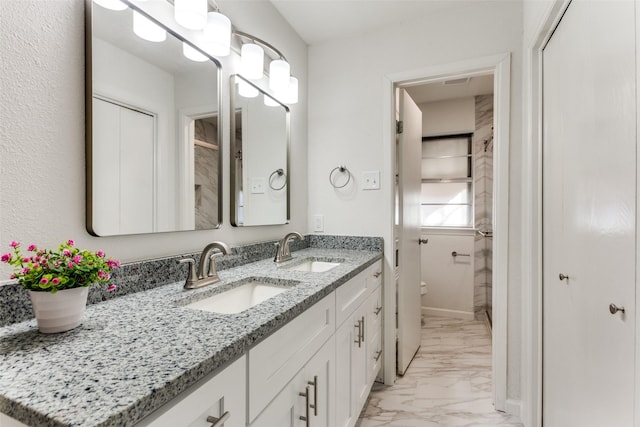 full bath with double vanity, marble finish floor, toilet, and a sink