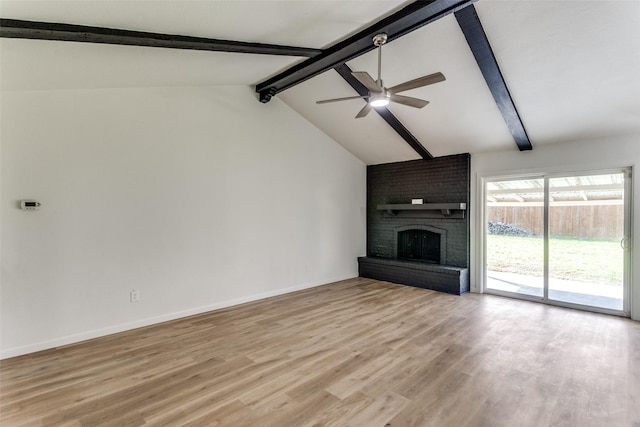 unfurnished living room featuring baseboards, a ceiling fan, lofted ceiling with beams, light wood-type flooring, and a brick fireplace