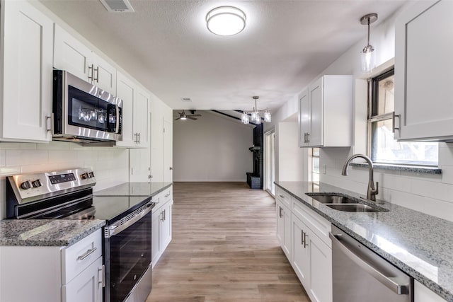 kitchen with light wood finished floors, visible vents, white cabinets, appliances with stainless steel finishes, and a sink