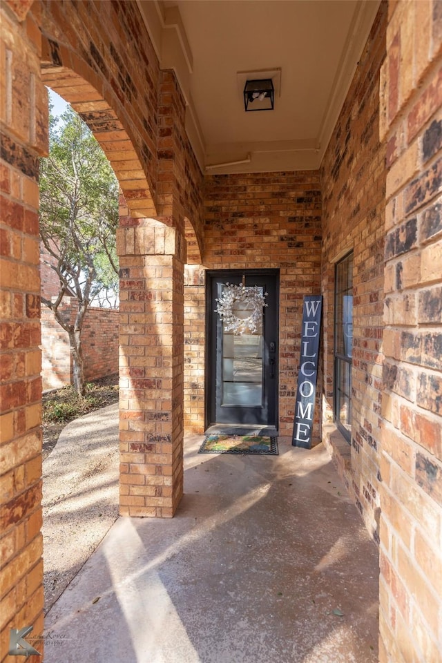 entrance to property featuring brick siding