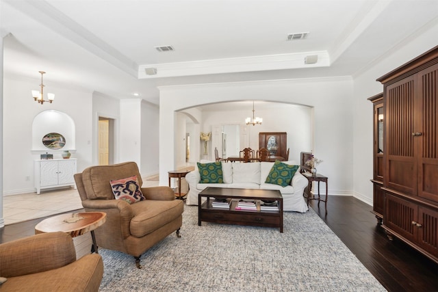 living room featuring visible vents, a chandelier, and a tray ceiling