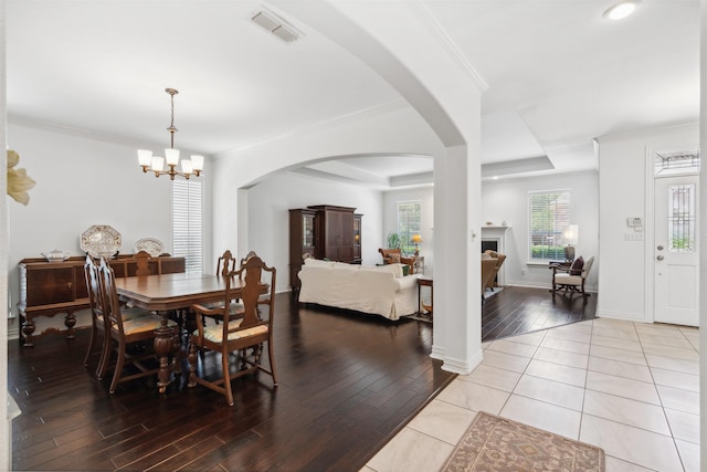 dining room featuring visible vents, wood finished floors, and ornamental molding