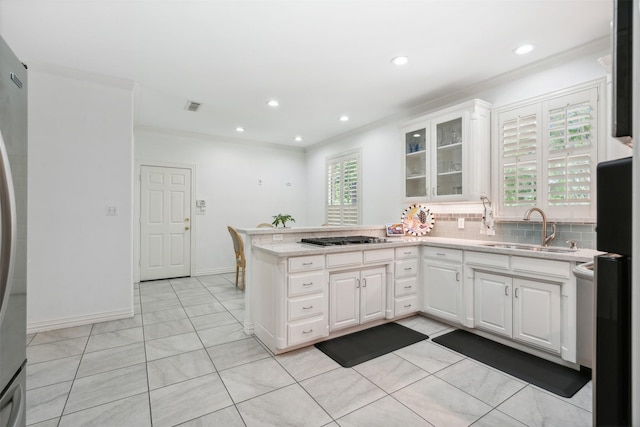 kitchen featuring stainless steel appliances, a peninsula, a sink, visible vents, and white cabinets