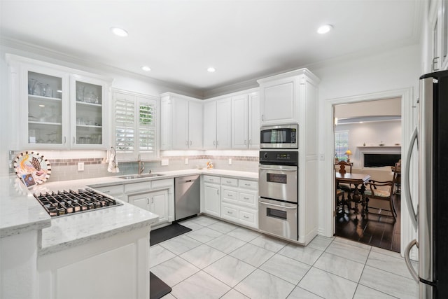 kitchen featuring white cabinets, appliances with stainless steel finishes, decorative backsplash, and a sink