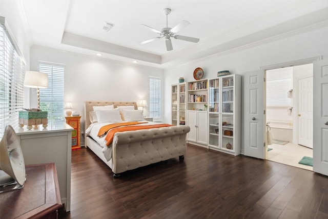 bedroom featuring visible vents, a tray ceiling, dark wood finished floors, and crown molding