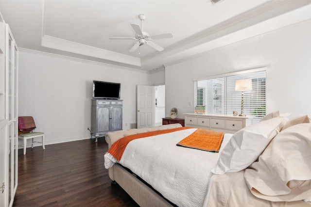 bedroom with baseboards, a tray ceiling, dark wood finished floors, and crown molding