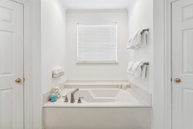 bathroom featuring a garden tub and ornamental molding