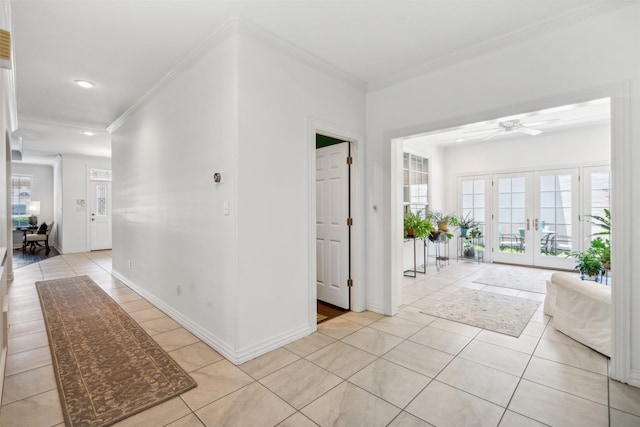 corridor with light tile patterned floors, ornamental molding, a wealth of natural light, and french doors