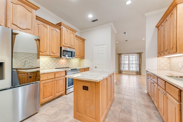 kitchen featuring a center island, stainless steel appliances, visible vents, ornamental molding, and light stone countertops