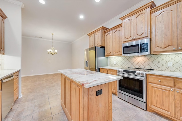 kitchen featuring appliances with stainless steel finishes, a kitchen island, light stone counters, and crown molding