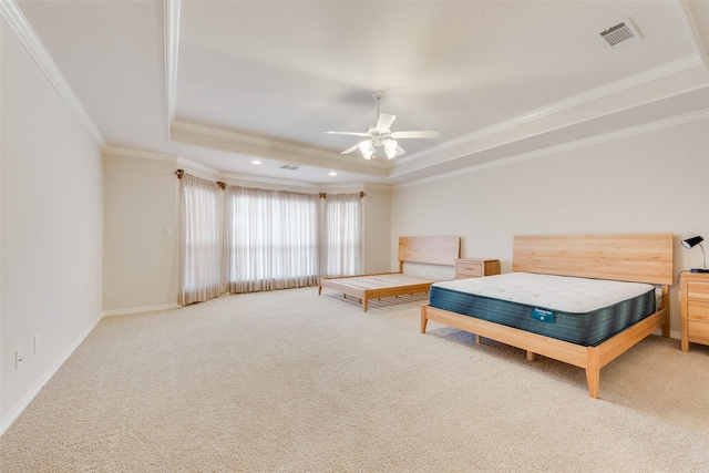 bedroom featuring visible vents, baseboards, carpet, a tray ceiling, and crown molding