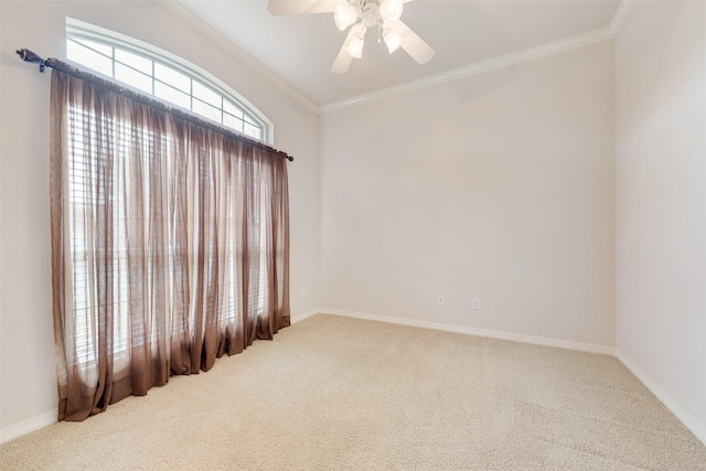 unfurnished room featuring a ceiling fan, carpet flooring, crown molding, and baseboards