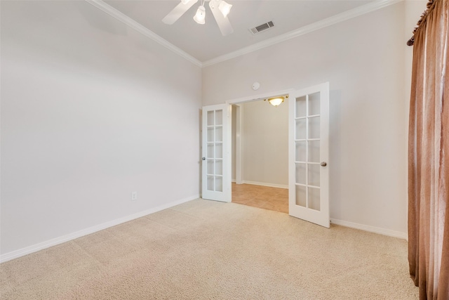 empty room with light carpet, visible vents, baseboards, french doors, and ornamental molding