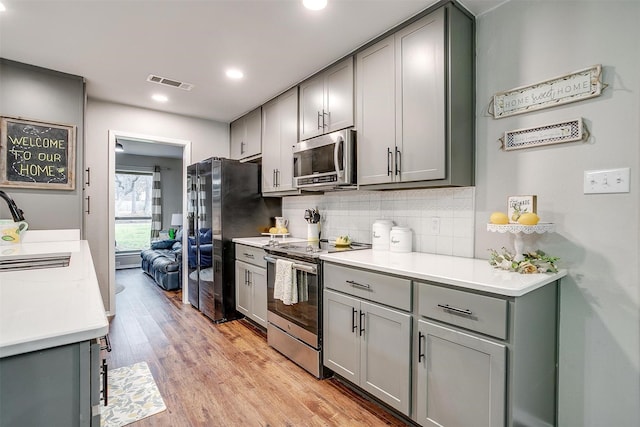 kitchen featuring a sink, stainless steel appliances, gray cabinets, and visible vents