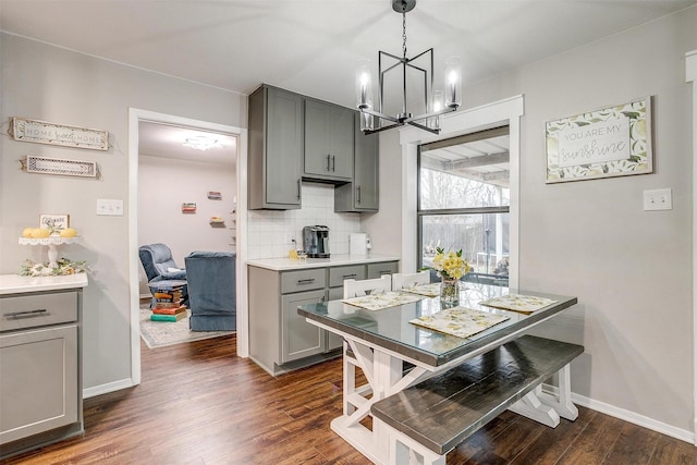 kitchen featuring dark wood-style floors, light countertops, backsplash, and gray cabinets