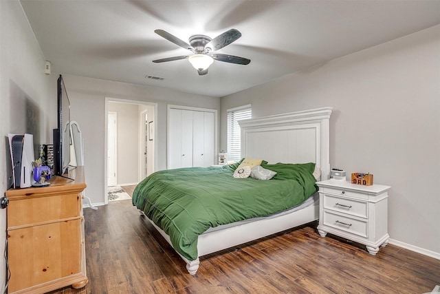 bedroom featuring dark wood-style flooring, a closet, visible vents, a ceiling fan, and baseboards