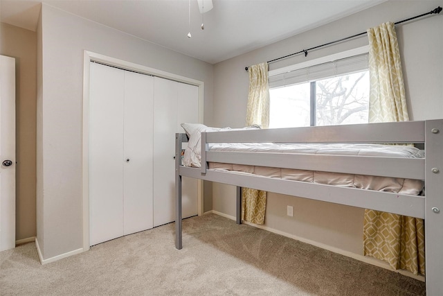 bedroom with carpet floors, baseboards, and a closet