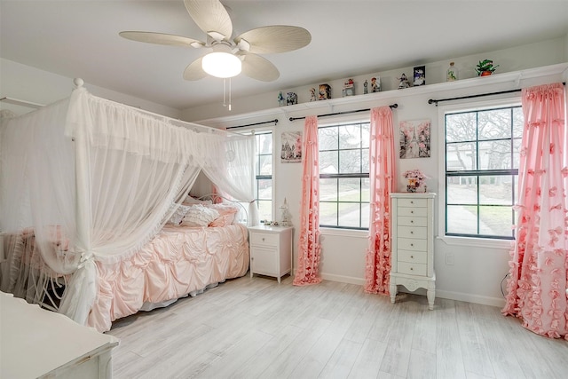 bedroom featuring light wood-style flooring, baseboards, and a ceiling fan