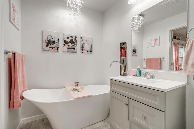 full bathroom with a freestanding tub, visible vents, and vanity