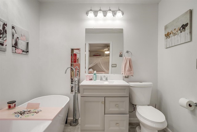 bathroom featuring toilet, baseboards, a freestanding bath, and vanity