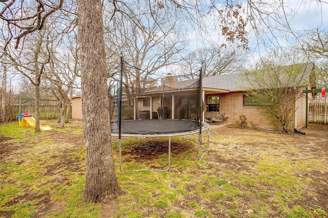 view of yard with a trampoline and fence