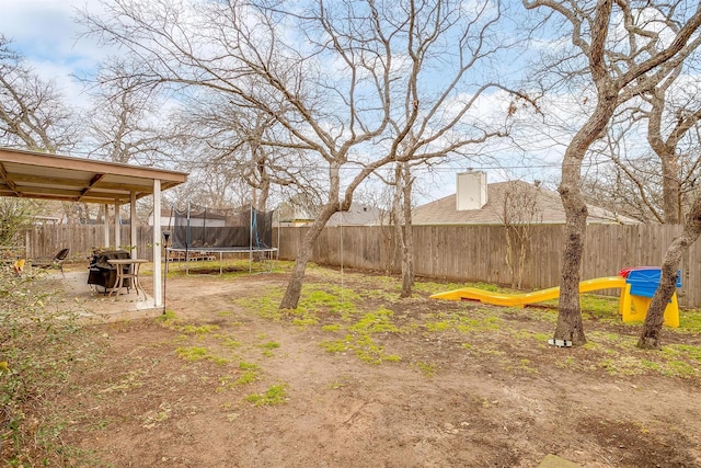 view of yard featuring a trampoline and a fenced backyard