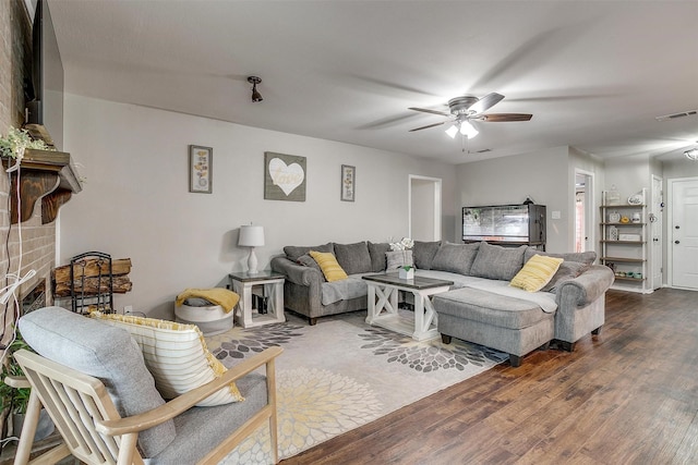 living room with ceiling fan, visible vents, and wood finished floors