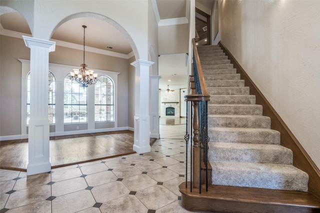 foyer entrance featuring ornamental molding, stairway, and ornate columns