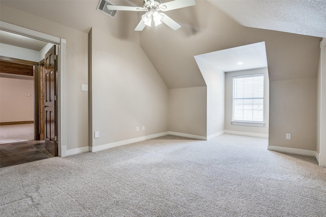 additional living space with lofted ceiling, visible vents, carpet flooring, ceiling fan, and baseboards