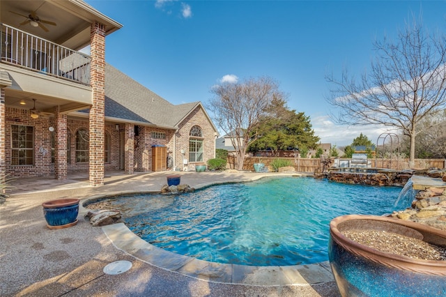 view of swimming pool with a pool with connected hot tub, a patio area, fence, and a ceiling fan