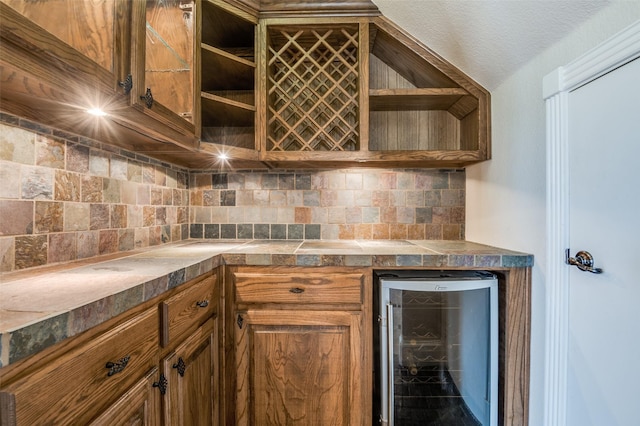 kitchen featuring open shelves, wine cooler, brown cabinetry, and tasteful backsplash