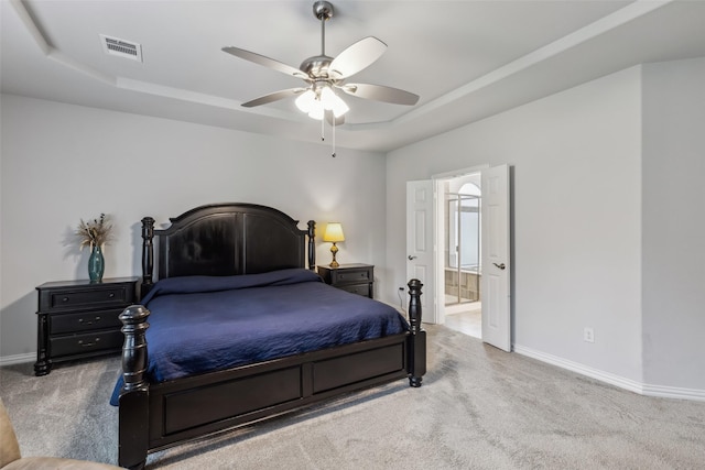 bedroom with carpet, visible vents, a tray ceiling, and baseboards