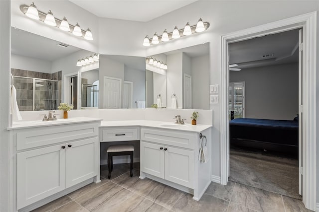 full bathroom with double vanity, a stall shower, a sink, and connected bathroom